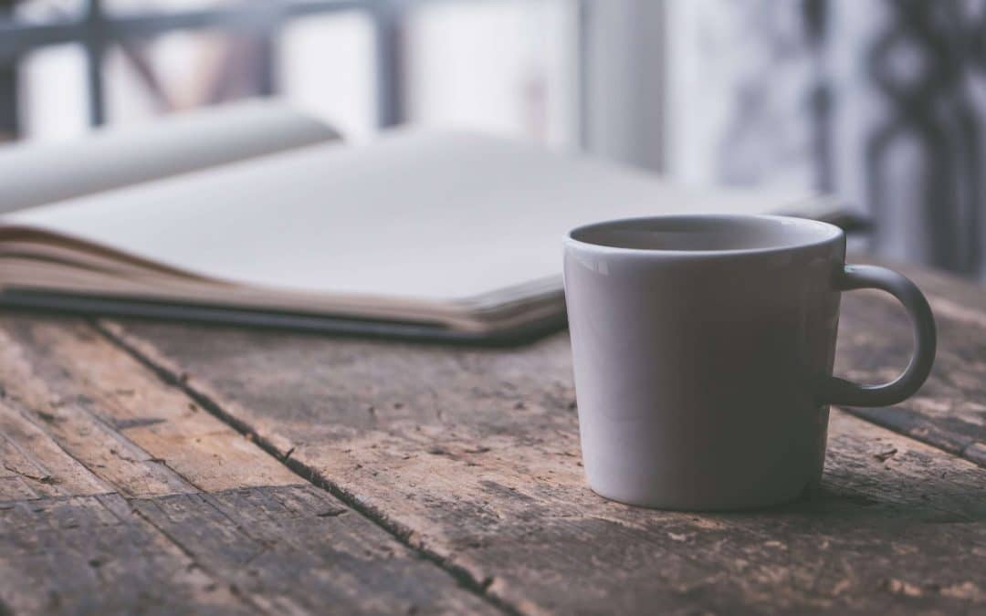 Cup of coffee and open notebook representing a calm space to consider family mediation options.