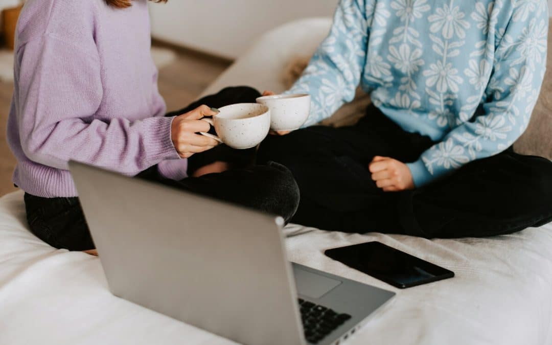 Mother and adult daughter talking over a cup of tea at home.