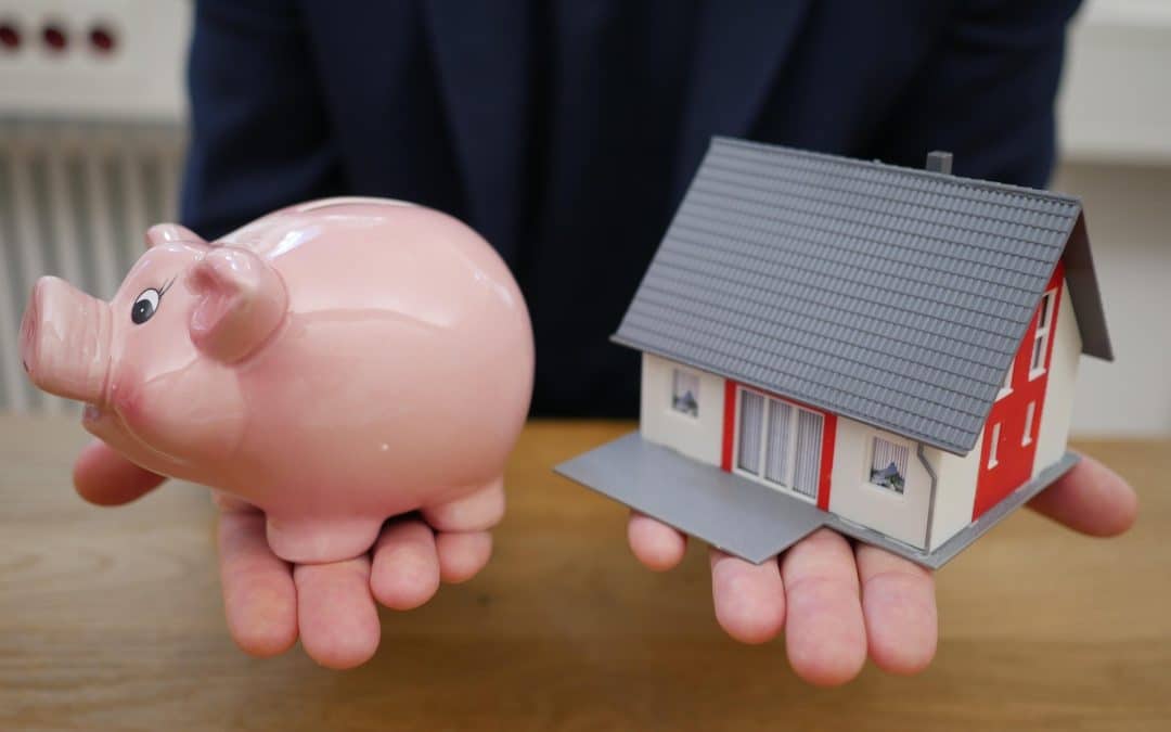 Piggy bank beside a house representing the cost of living apart after separation